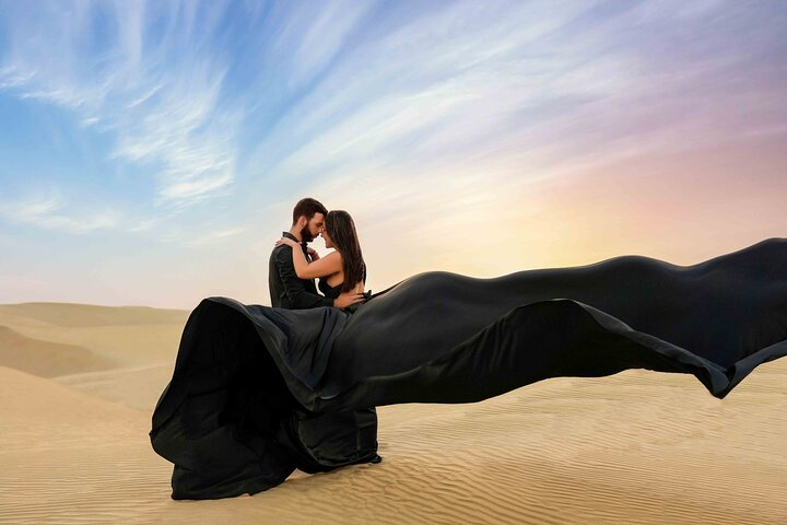 Experience a breathtaking Dubai desert sunset capturing precious moments with your partner while draped in a flowing dress creating a stunning backdrop for unforgettable memories.